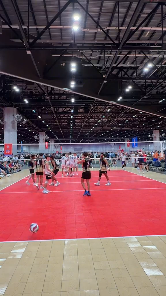Volleyball teams and families between rallies at a live tournament